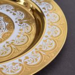 Gold dish painted with a pattern and hand engraved