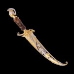 Exclusive handmade work. Knife decorated with dice and cast elements in the ancient Greek style. The sheath with the handle is strewn with crystals of various shapes and colors.