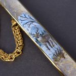 Artistic image of a deer on a metal sheath of a dagger. Handmade souvenir dagger.