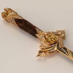Exclusive wood and gold hilt. A large stone in the guard is surrounded by small stones of different colors.