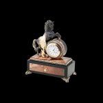 Handmade box made of natural stone. A round clock with a graceful horse is located on the casket.