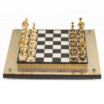 Chess board. Classic handmade chess made of stone and gold. In the corners, chess is decorated with malachite cabochons.