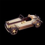 A large model of a retro car carved from wood and decorated with gold lining. Luxury gift to decorate your office