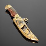 decorated gold knife with a wooden handle