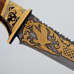 Damascus steel blade with golden ornament