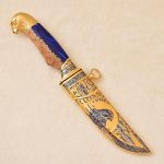 Golden knife with a falcon's head on the handle